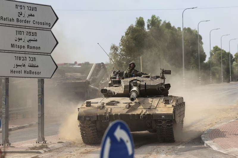 Israeli soldiers drive in a tank by Israel's border with Gaza in southern Israel, October 10, 2023. PHOTO: REUTERS