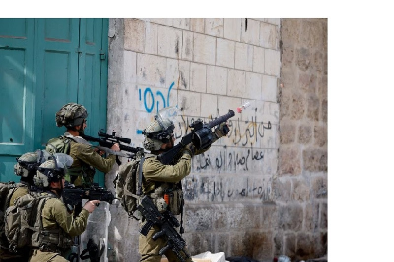 an israeli soldier uses a weapon amid clashes with palestinian protesters in hebron in the israeli  occupied west bank april 1 2022 photo reuters