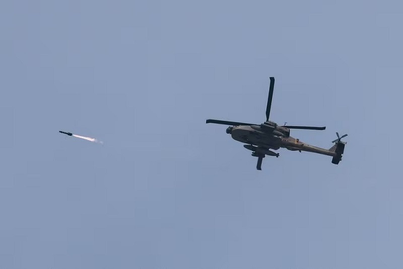 An Israeli military Apache helicopter fires a missile near Israel-Gaza border as seen from southern Israel, December 23, 2023. PHOTO: REUTERS
