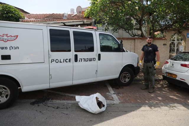 an israeli police officer stands next to the remains of a rocket in herzliya israel may 26 2024 photo reuters an israeli police officer stands next to the remains of a rocket in herzliya israel may 26 2024 photo reuters