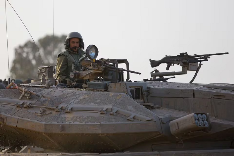 An Israeli soldier sits atop a tank near the Israel-Gaza border on its Israeli side in southern Israel, November 26, 2023. PHOTO: REUTERS