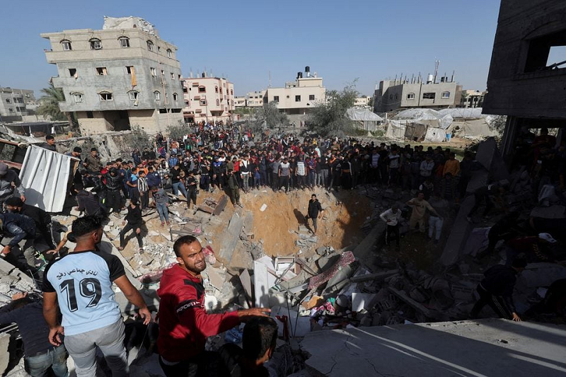 Palestinians gather as others search for casualties at the site of an Israeli strike on a house in Rafah in the southern Gaza Strip November 23. PHOTO: REUTERS