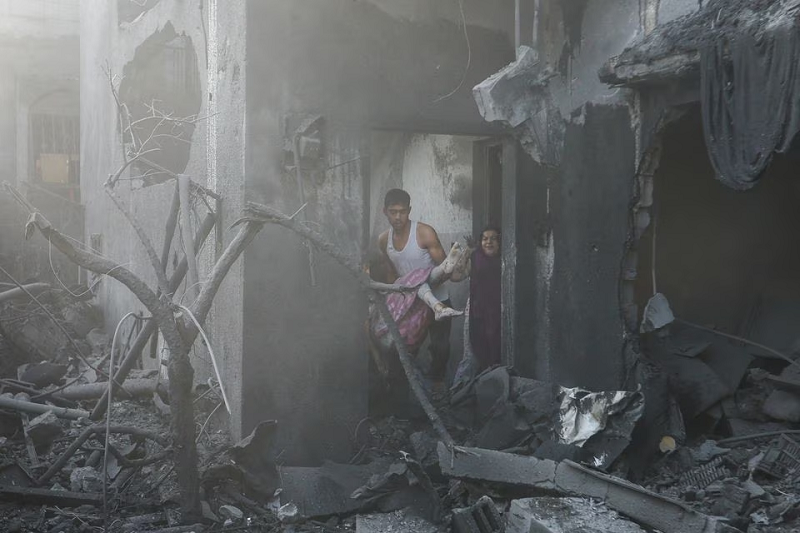 a man carries a wounded palestinian girl at the site of israeli strikes on a house in khan younis in the southern gaza strip october 11 photo reuters