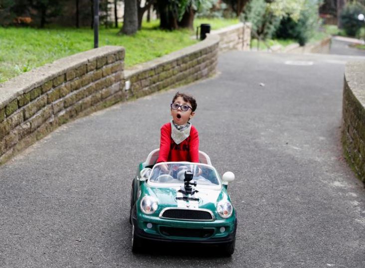 sirio persichetti a 7 year old italian with spastic tetraplegia and cerebral palsy who has become an influencer by challenging perceptions of disability drives his toy car in the frontyard of his home in rome italy october 23 2020 picture taken october 23 2020 reuters