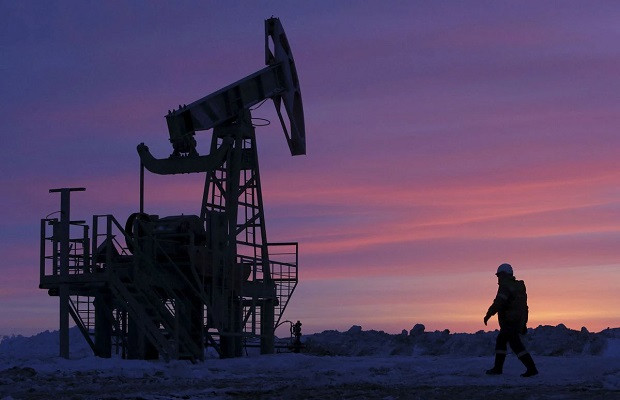 a worker walks past a pump jack on an oil field owned by bashneft company near the village of nikolo berezovka northwest from ufa bashkortostan russia january 28 2015 reuters