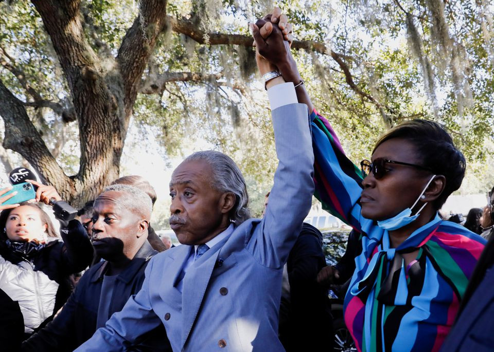 reverend al sharpton and wanda cooper jones mother of ahmaud arbery raise their hands outside the glynn county courthouse after the jury reached a guilty verdict in the trial of william roddie bryan travis mcmichael and gregory mcmichael charged with the february 2020 death of 25 year old ahmaud arbery in brunswick georgia u s november 24 2021 reuters