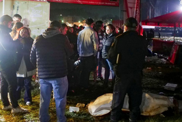 paramedics and government officials stand next a body covered at a scene following a stampede at a concert to commemorate the country s independence day that left people dead and injured in quetzaltenango guatemala september 15 2022 reuters stringer
