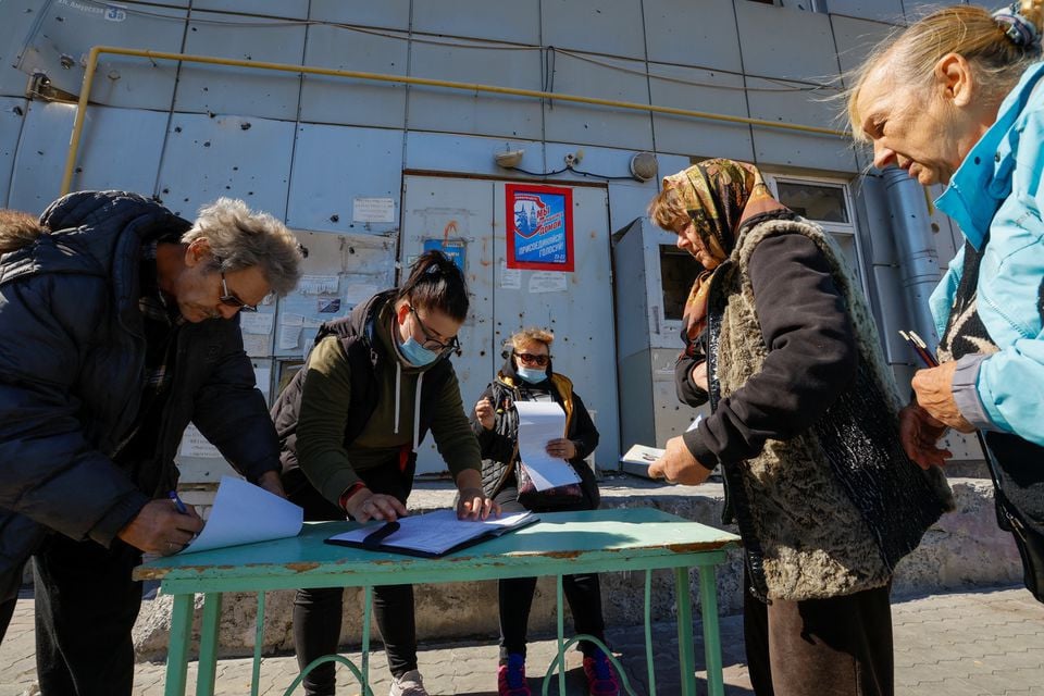 local residents wait before receiving ballots from members of an electoral commission and casting their votes into a mobile ballot box on the third day of a referendum on the joining of the self proclaimed donetsk people s republic dpr to russia in mariupol ukraine september 25 2022 photo reuters