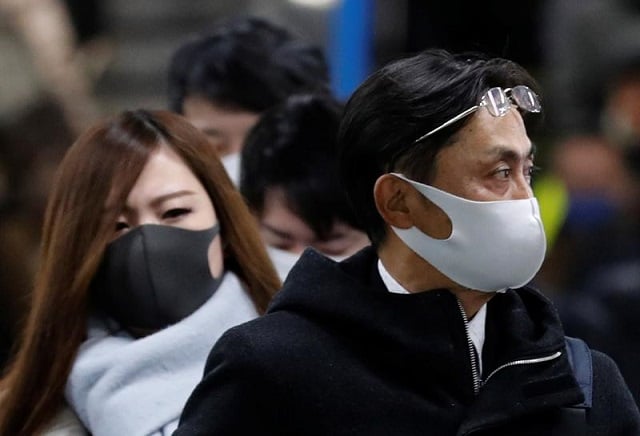 pedestrians wearing protective masks following the coronavirus disease covid 19 outbreak walk out of a station during a commuting hour at a business district in tokyo japan january 7 2021 photo reuters