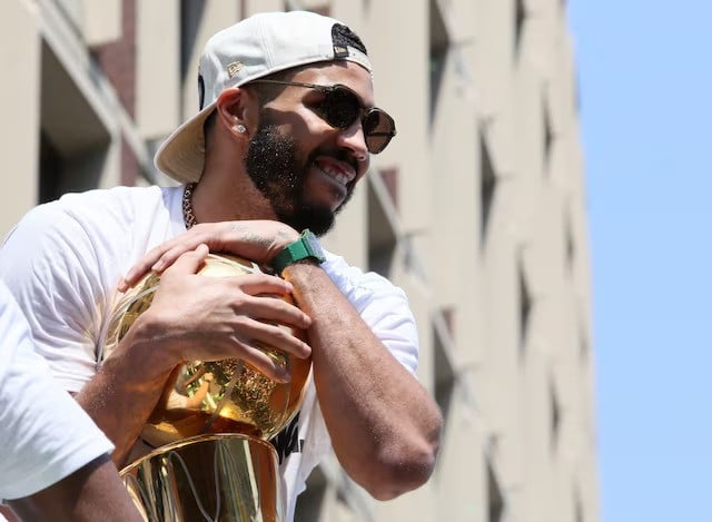 jayson tatum holds the trophy during a parade to celebrate the boston celtics 18th nba championship in boston massachusetts us june 21 2024 photo reuters