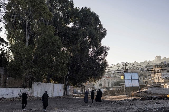 Palestinian women walk early morning past the Children’s cemetery in the Jenin refugee camp, on December 15, 2023. The West Bank, which is ruled by the Palestinian Authority (PA), has seen a surge in violence since the October 7 attacks in southern Israel. PHOTO: AFP