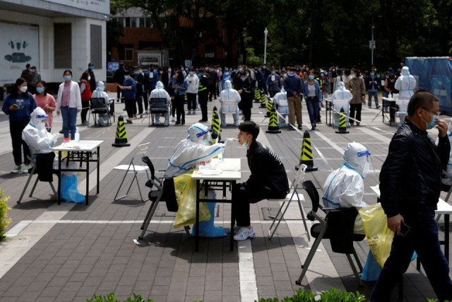 a medical worker in a protective suit collects a swab sample from a resident at a makeshift nucleic acid testing site amid the coronavirus disease covid 19 outbreak in beijing china april 28 2022 reuters a medical worker in a protective suit collects a swab sample from a resident at a makeshift nucleic acid testing site amid the coronavirus disease covid 19 outbreak in beijing china april 28 2022 reuters