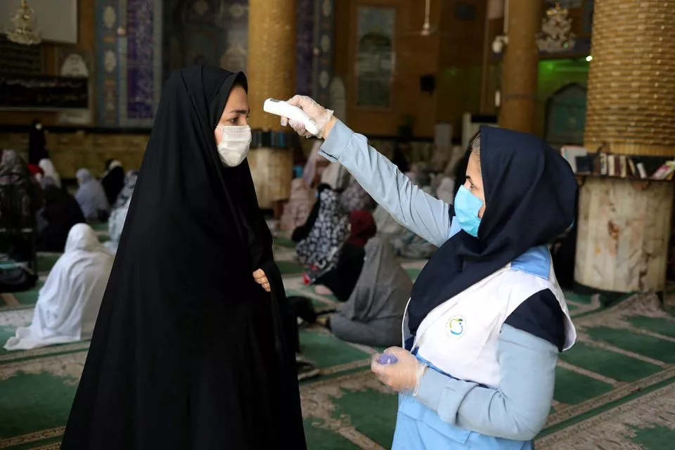 an iranian woman wearing a protective face mask checks the temperature of a worshipper before attending the friday prayers in qarchak jamee mosque following the outbreak of the coronavirus disease covid 19 in tehran province in qarchak iran june 12 2020 wana west asia news agency ali khara via reuters an iranian woman wearing a protective face mask checks the temperature of a worshipper before attending the friday prayers in qarchak jamee mosque following the outbreak of the coronavirus disease covid 19 in tehran province in qarchak iran june 12 2020 wana west asia news agency ali khara via reuters