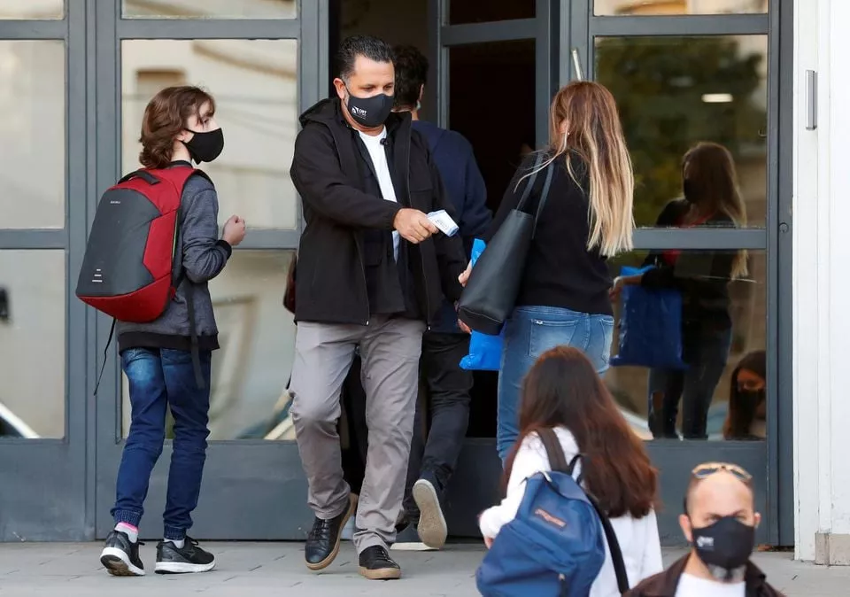 an employee checks the temperature of a woman at the entrance to a school amid a rise in coronavirus disease covid 19 cases in buenos aires argentina photo reuters an employee checks the temperature of a woman at the entrance to a school amid a rise in coronavirus disease covid 19 cases in buenos aires argentina photo reuters