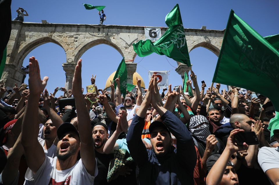 people hold hamas flags as palestinians gather after performing the last friday of ramadan to protest over the possible eviction of several palestinian families from homes on land claimed by jewish settlers in the sheikh jarrah neighbourhood in jerusalem s old city may 7 2021 reuters
