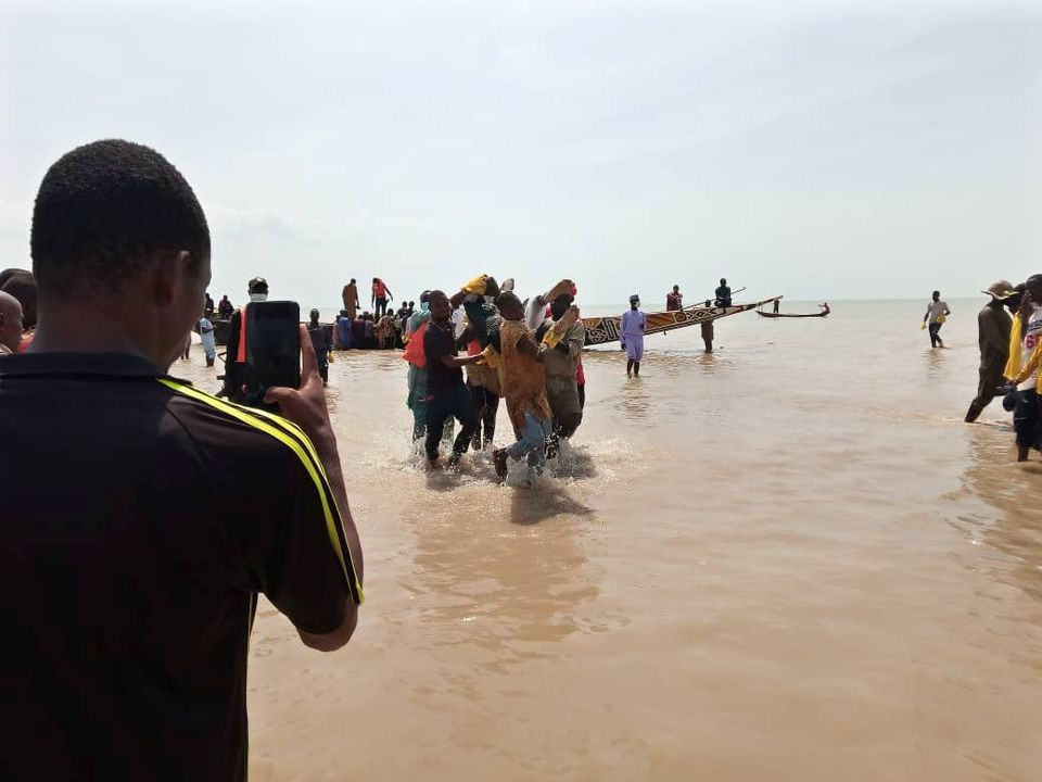 a man takes a picture as the body of one of the victims of a boat accident is being retrieved from the boat in kebbi nigeria photo reuters