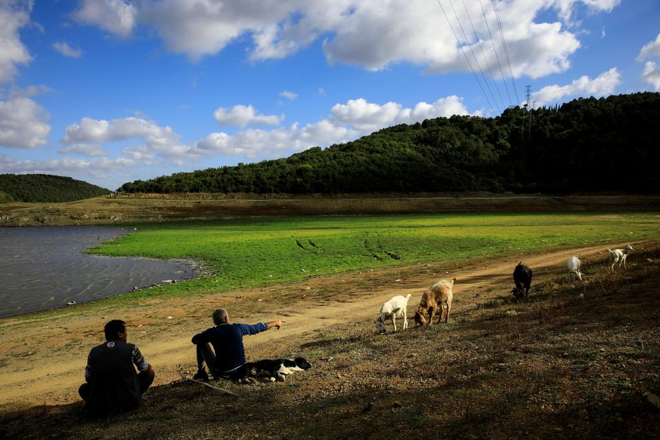 men chat by the shores of partly dried out waters near alibeykoy dam north of istanbul turkey september 16 2020 reuters