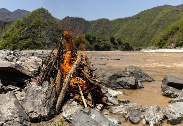 the burning pyre of pramila devi 36 who died from complications related to the coronavirus disease covid 19 is seen during her cremation on the banks of the river ganges in pauri garhwal in the northern state of uttarakhand india may 24 2021 devi s eldest daughter got married and moved away in late april after the family hosted a ceremony attended by over two dozen people her husband suresh kumar 43 told reuters two weeks after that devi suffered a bout of diarrhoea but it was not until 10 days later that kumar who has no income and depends on handouts took her to a nearby dispensary that has been turned into a small covid 19 facility with four beds devi tested positive for covid 19 with very low blood oxygen levels she died a day later reuters the burning pyre of pramila devi 36 who died from complications related to the coronavirus disease covid 19 is seen during her cremation on the banks of the river ganges in pauri garhwal in the northern state of uttarakhand india may 24 2021 devi s eldest daughter got married and moved away in late april after the family hosted a ceremony attended by over two dozen people her husband suresh kumar 43 told reuters two weeks after that devi suffered a bout of diarrhoea but it was not until 10 days later that kumar who has no income and depends on handouts took her to a nearby dispensary that has been turned into a small covid 19 facility with four beds devi tested positive for covid 19 with very low blood oxygen levels she died a day later reuters