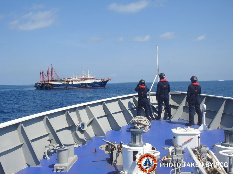 philippine coast guard personnel survey several ships believed to be chinese militia vessels in sabina shoal in the south china sea in a handout photo distributed by the philippine coast guard on may 5 and taken according to source on april 27 2021 philippine coast guard photo reuters