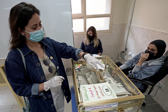 a kuwaiti woman casts her vote at a polling station during parliamentary elections in jahra city kuwait december 5 2020 photo reuters