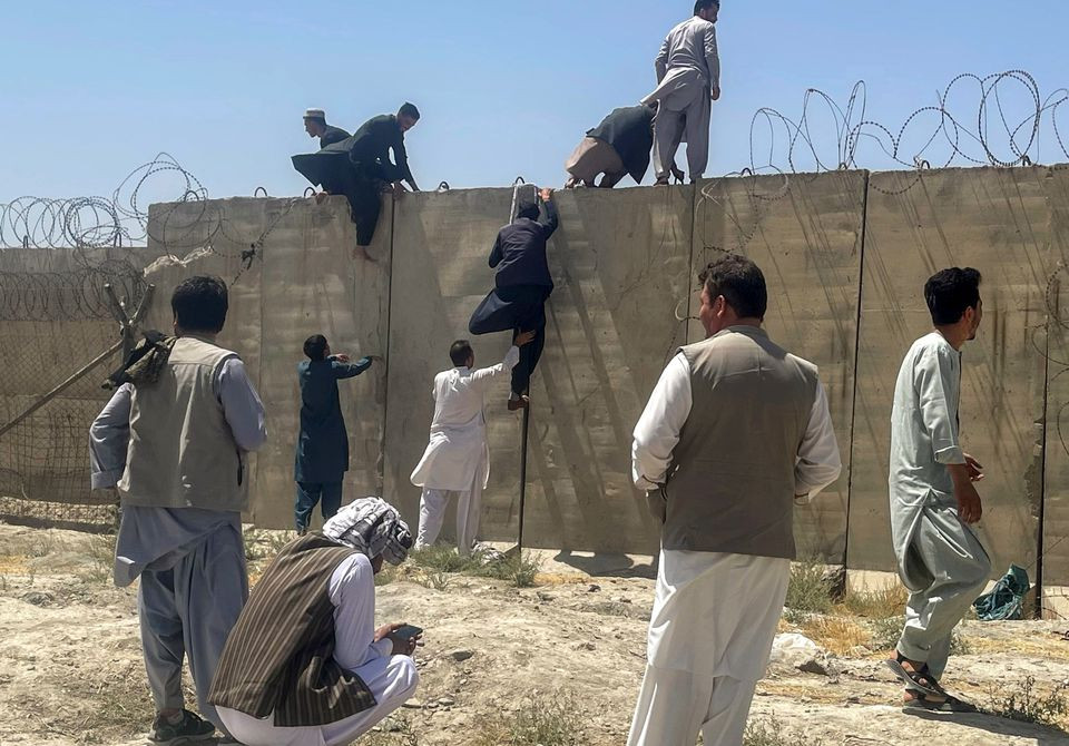 men try to get inside hamid karzai international airport in kabul afghanistan august 16 2021 photo reuters