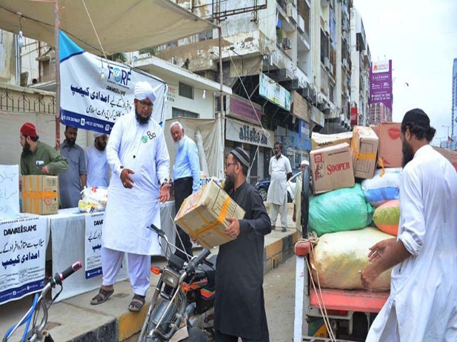 a man donating ration bags to a flood relief camp app photo by m saeed qureshi