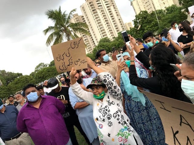 woman holding a placard as scores of people including children gathered at karachi s frere hall on friday evening to protest against the waterlogged city photo express