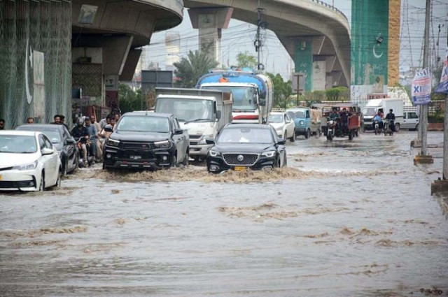 commuters are passing through accumulated rainwater at qayumabad road photo app file commuters are passing through accumulated rainwater at qayumabad road photo app file