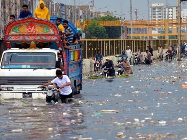 people wade through a flooded street after heavy monsoon rains in karachi photo afp file people wade through a flooded street after heavy monsoon rains in karachi photo afp file