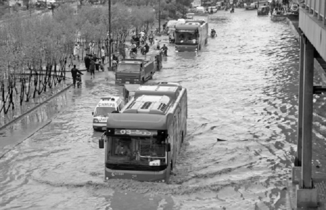 vehicles move on a flooded road in central district where the drainage system has collapsed causing urban flooding even in light rain photo online