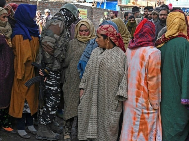 a paramilitary soldier walks next to voters queueing to cast their ballots at a polling station in indian occupied kashmir photo afp a paramilitary soldier walks next to voters queueing to cast their ballots at a polling station in indian occupied kashmir photo afp