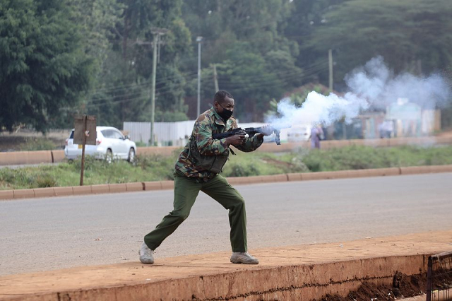 a police officers fires tear gas at protesters during clashes that erupted after a kenyan police officer shot dead several people and himself in a rampage attack in nairobi kenya december 7 2021 photo reuters