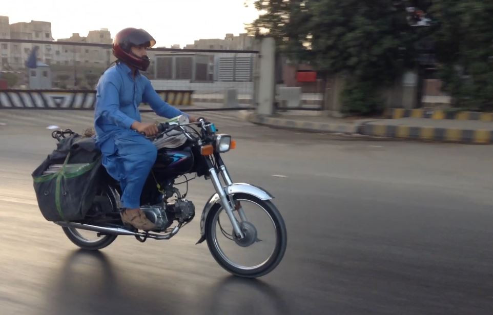 Khalid Khan on way to Qayyumabad to deliver newspapers. PHOTO: Jahanzeb Tahir