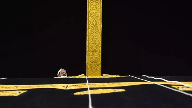 a saudi worker adjusts the new kiswah the gold embroidered black cloth covering the kaaba that is changed during each year s hajj photo afp a saudi worker adjusts the new kiswah the gold embroidered black cloth covering the kaaba that is changed during each year s hajj photo afp