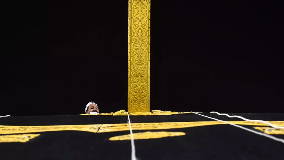 a saudi worker adjusts the new kiswah the gold embroidered black cloth covering the kaaba that is changed during each year s hajj photo afp