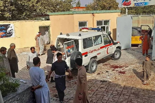 afghan men stand next to an ambulance after a bomb attack at a mosque in kunduz on october 8 2021 photo afp afghan men stand next to an ambulance after a bomb attack at a mosque in kunduz on october 8 2021 photo afp