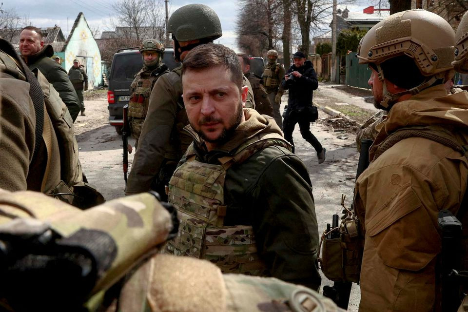 ukraine s president volodymyr zelenskiy looks on as he is surrounded by ukrainian servicemen as russia s invasion of ukraine continues in bucha outside kyiv ukraine april 4 2022 reuters