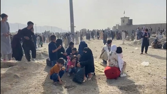 People gathered outside the airport react to gunfire, in Kabul, Afghanistan August 18, 2021 in this still image taken from video. PHOTO: REUTERS