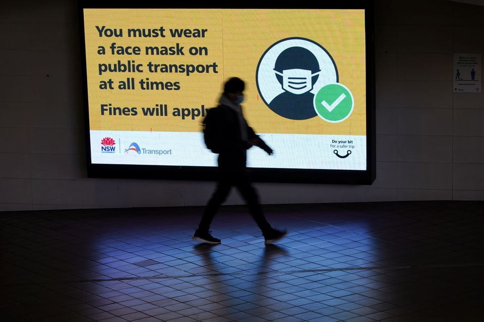 a person walks past a public health warning for passengers to wear face masks at a city centre transit station during a lockdown to curb the spread of an outbreak of the coronavirus disease covid 19 in sydney australia august 17 2021 photo reuters