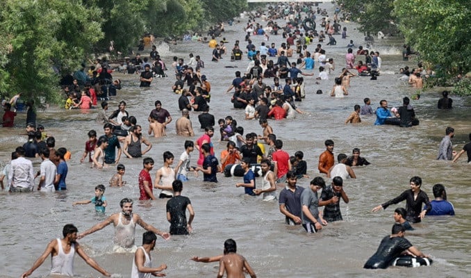 people take a dip in a canal to cool off on a hot summer afternoon in lahore on may 19 2024 photo afp