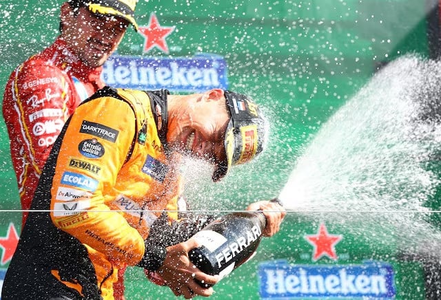 mclaren s lando norris celebrates with champagne on the podium after winning the dutch grand prix with third placed ferrari s charles leclerc at circuit zandvoort zandvoort netherlands on august 25 2024 photo reuters