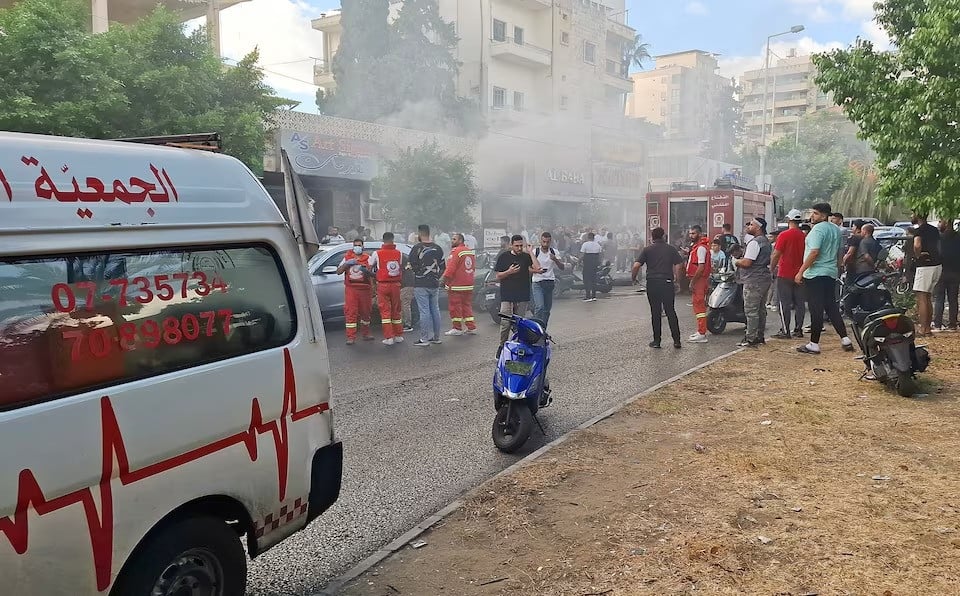 smoke rises from a mobile shop as civil defence members gather in sidon lebanon on september 18 2024 photo reuters