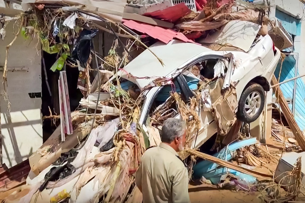 A destroyed vehicle crashed into a building in the wake of floods in Derna. PHOTO: AFP