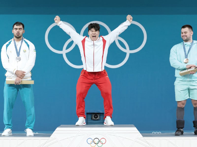 gold medallist huanhua liu of china celebrates on the podium with silver medallist akbar djuraev of uzbekistan and bronze medallist yauheni tsikhantsou of ain photo reuters