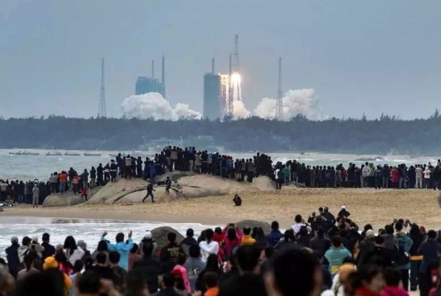 people watch the medium lift long march 8 y 1 rocket taking off from wenchang space launch centre on a beach in wenchang hainan province china december 22 2020 photo afp