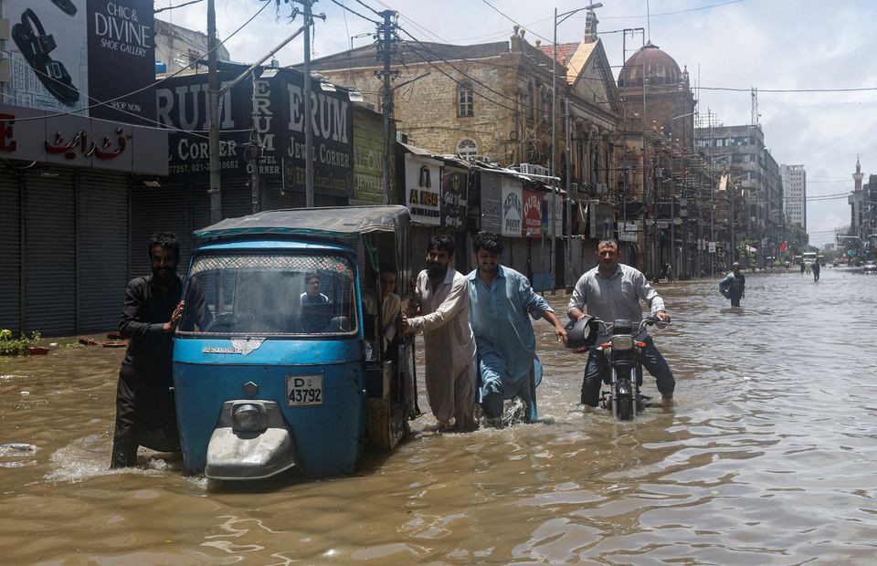 residents commute through a flooded street during the monsoon season in karachi pakistan july 11 2022 reuters