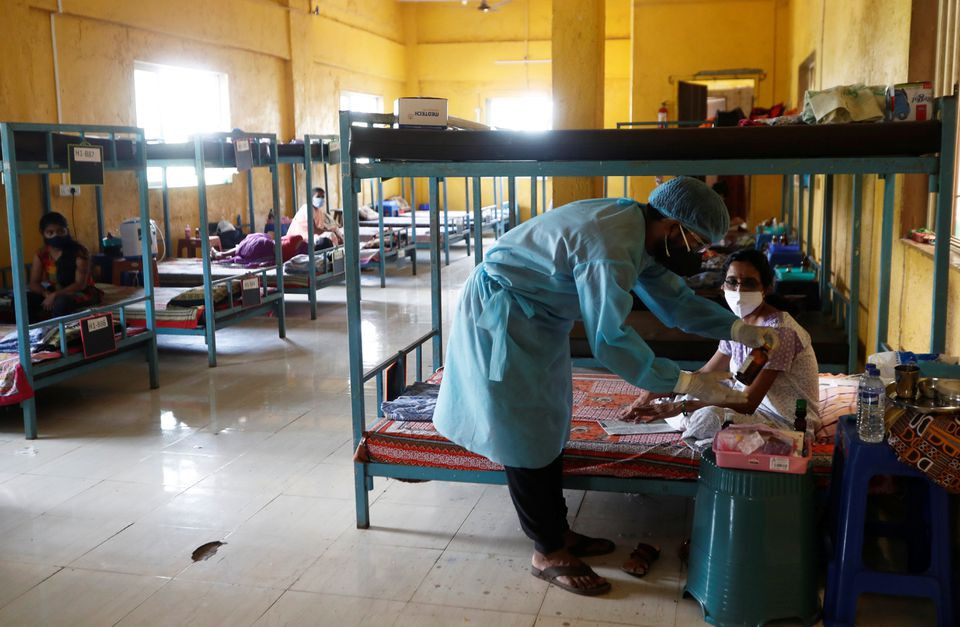 a doctor checks the medicines of a patient suffering from coronavirus disease covid 19 inside a classroom turned covid 19 care facility on the outskirts of mumbai india may 24 2021 reuters