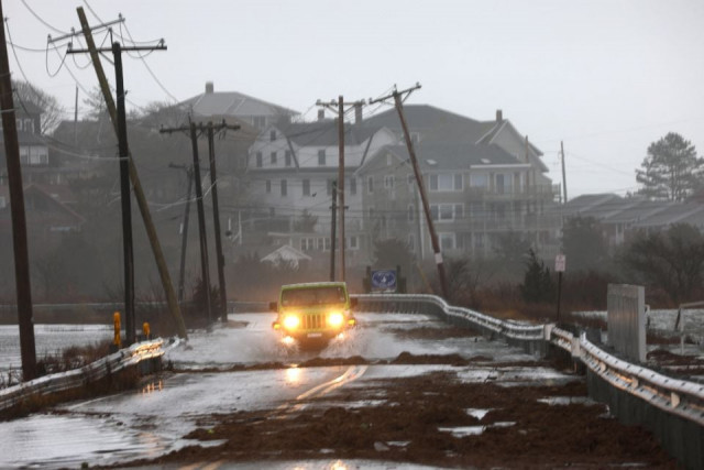 a driver makes their way through a flooded street at high tide during a winter storm in gloucester massachusetts u s december 23 2022 reuters brian snyder a driver makes their way through a flooded street at high tide during a winter storm in gloucester massachusetts u s december 23 2022 reuters brian snyder