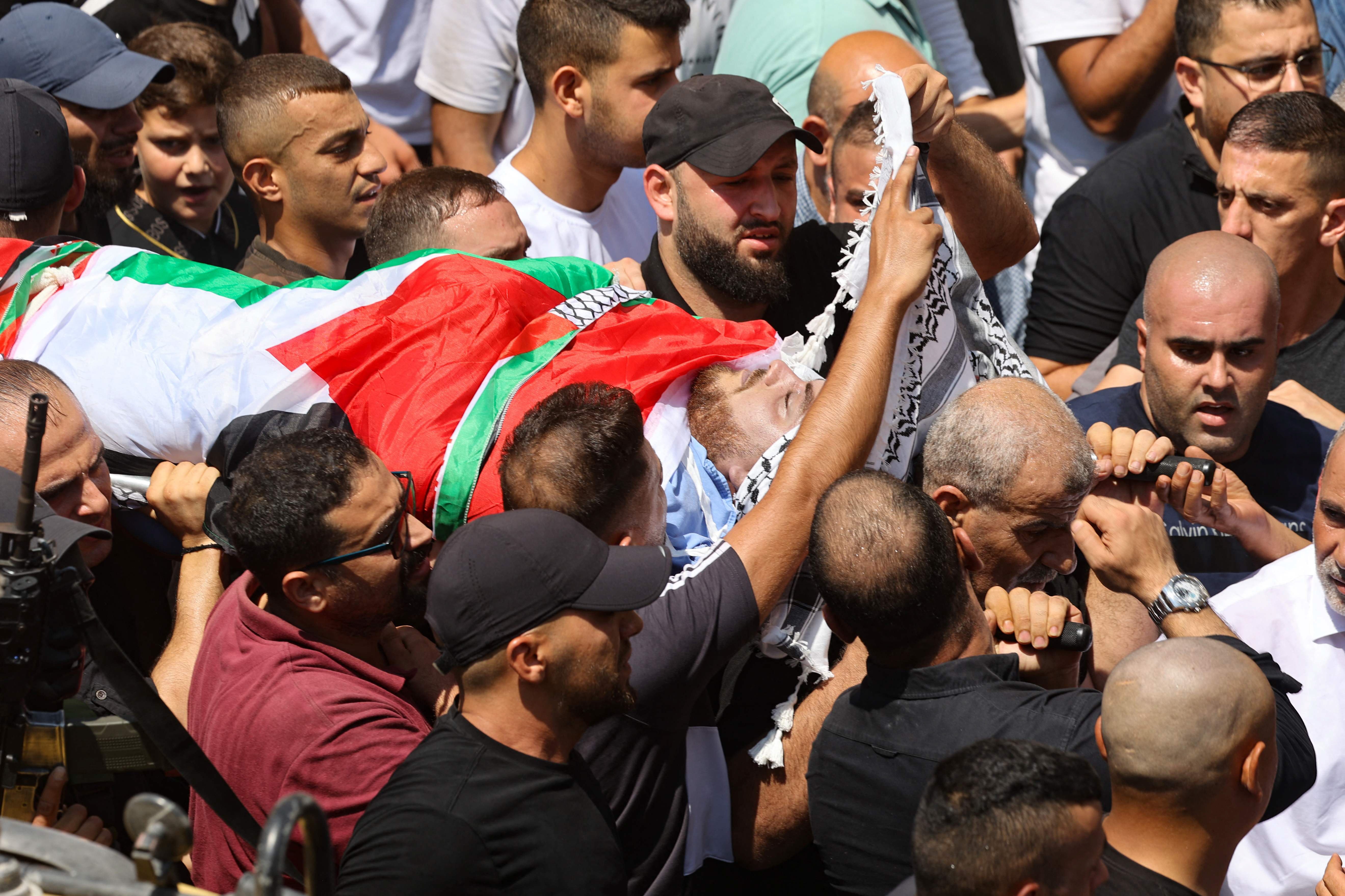 mourners the flag draped body of mahmoud jarad a palestinian youth reportedly shot during an israeli military raid on tulkarem refugee camp in the northern occupied west bank on august 11 2023 photo afp