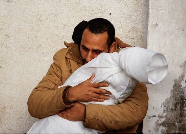 a palestinian man reacts while carrying the body of his daughter who was killed in an israeli strike at abu yousef al najjar hospital in rafah in the southern gaza strip february 21 2024 photo reuters
